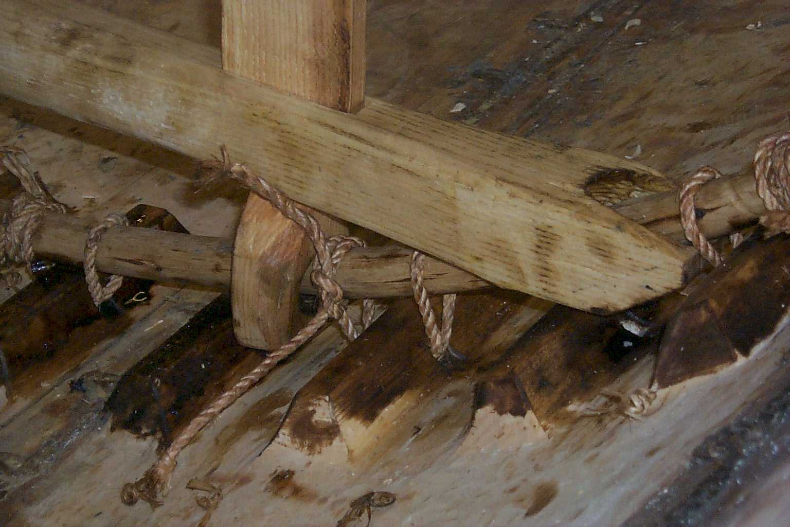 A close-up of a deck-beam - pillar - hazel branch connection.